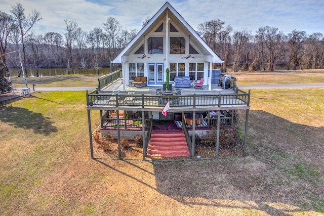 view of front of house with ceiling fan, french doors, a deck with water view, and a front yard