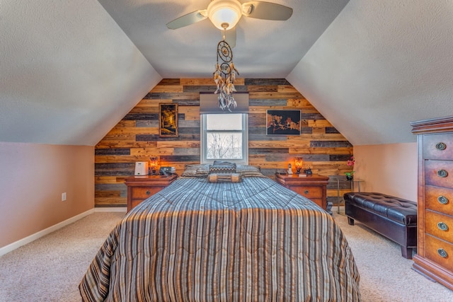 carpeted bedroom featuring ceiling fan, a textured ceiling, and wooden walls