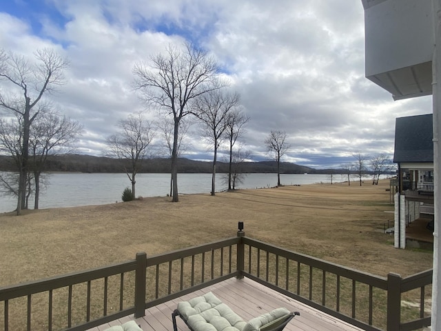 deck with a yard and a water view