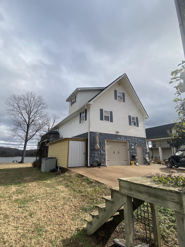 exterior space featuring a yard, a water view, and a garage