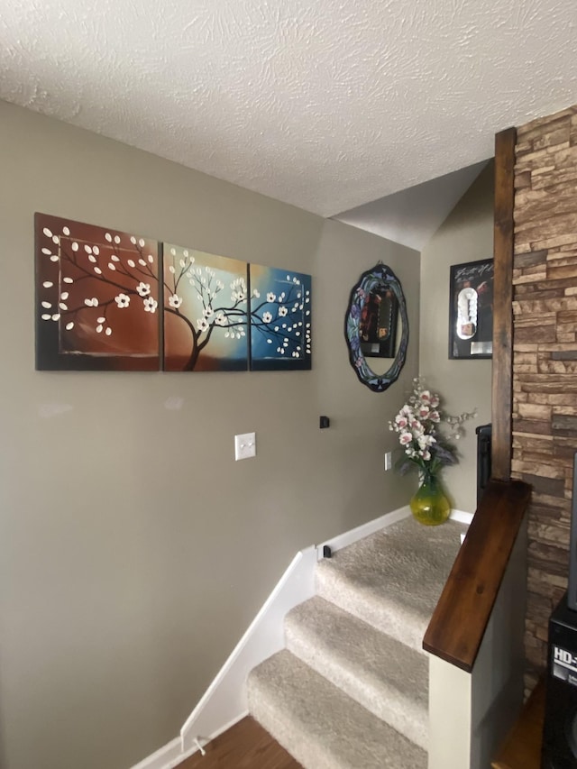 stairs with hardwood / wood-style flooring and a textured ceiling