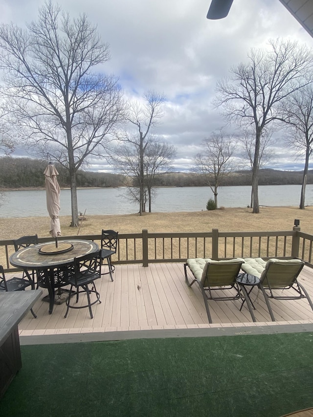 wooden terrace featuring a water view and an outdoor fire pit