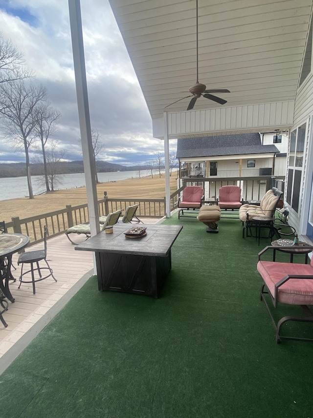 view of patio / terrace with ceiling fan, a water view, and an outdoor living space with a fire pit