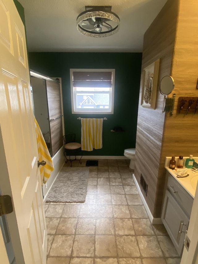 bathroom featuring ceiling fan, wooden walls, vanity, and toilet