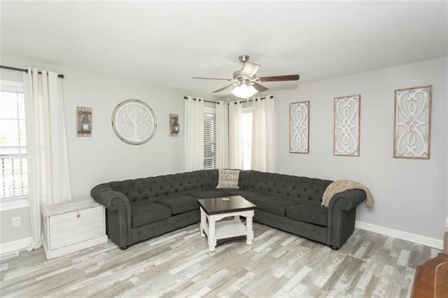 living room featuring ceiling fan, a healthy amount of sunlight, and light hardwood / wood-style flooring