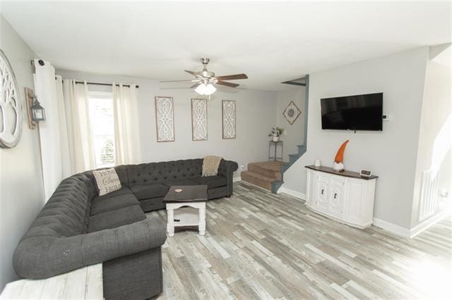 living room with light hardwood / wood-style floors and ceiling fan