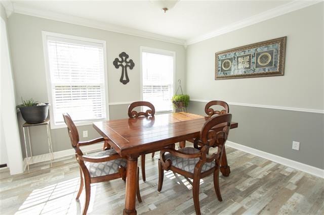 dining area with hardwood / wood-style flooring and crown molding