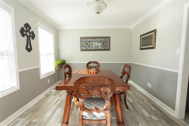 dining room featuring plenty of natural light, wood-type flooring, and ornamental molding