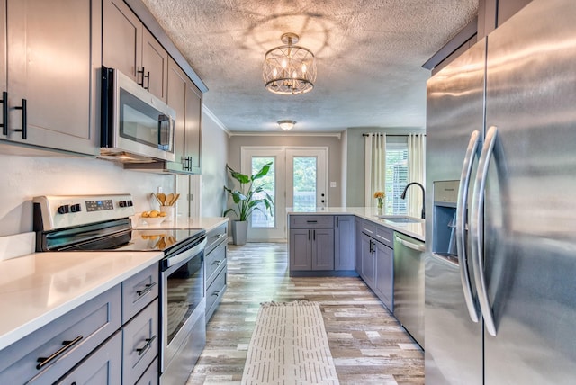 270 River Chase Rd, Allensville, KY 42204 - kitchen featuring appliances with stainless steel finishes, a sink, crown molding, light wood-style flooring, and gray cabinets