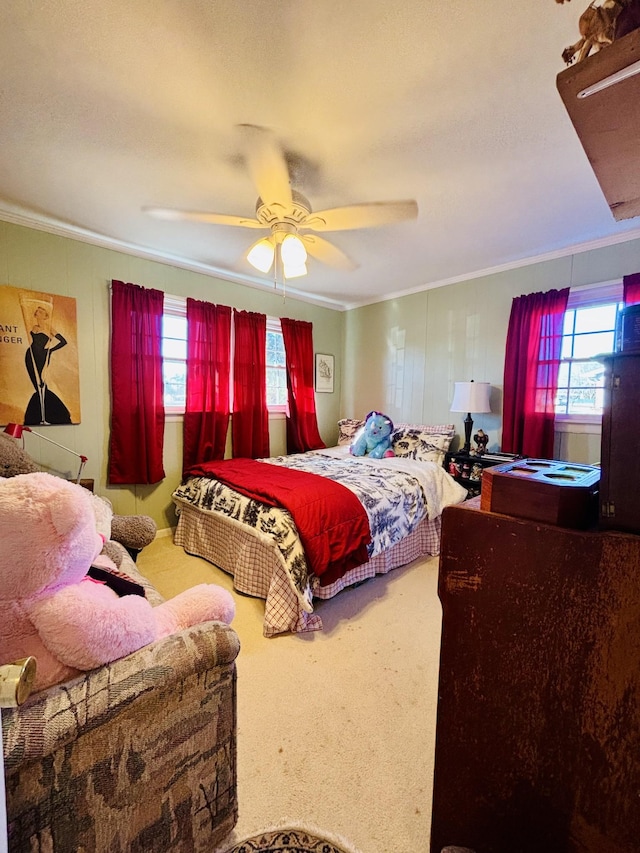 carpeted bedroom with ceiling fan and ornamental molding