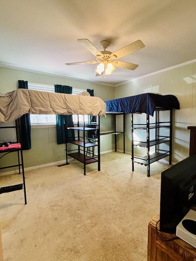 carpeted bedroom with ornamental molding and ceiling fan