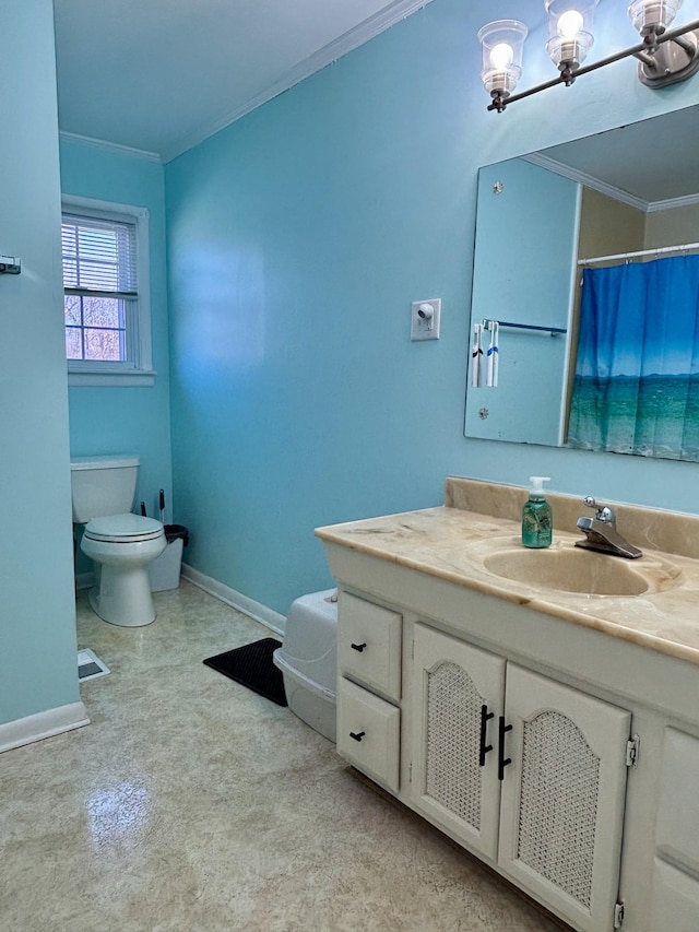 bathroom featuring a notable chandelier, ornamental molding, vanity, and toilet