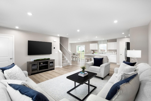 living room featuring sink and light hardwood / wood-style floors