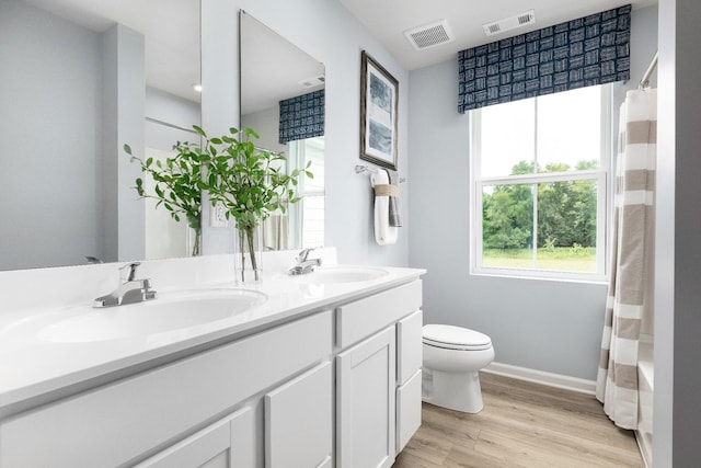 full bathroom featuring shower / bathtub combination with curtain, vanity, wood-type flooring, and toilet