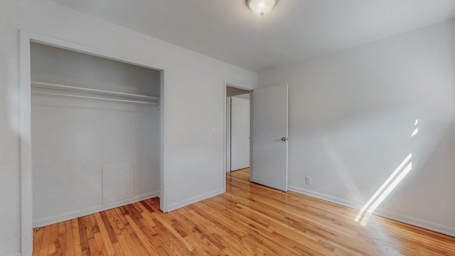 unfurnished bedroom with light hardwood / wood-style floors and a closet