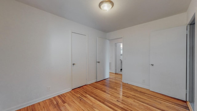 unfurnished bedroom with light hardwood / wood-style floors and a closet