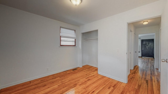 unfurnished bedroom with light hardwood / wood-style floors and a closet