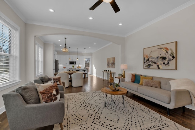 living room with hardwood / wood-style flooring, ornamental molding, ceiling fan, and a healthy amount of sunlight