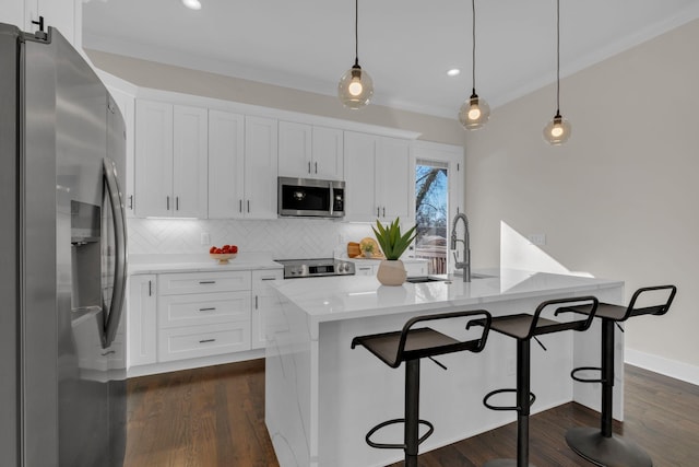 kitchen with hanging light fixtures, white cabinets, and stainless steel appliances