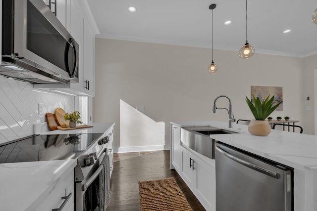 kitchen with decorative backsplash, light stone countertops, white cabinetry, and appliances with stainless steel finishes