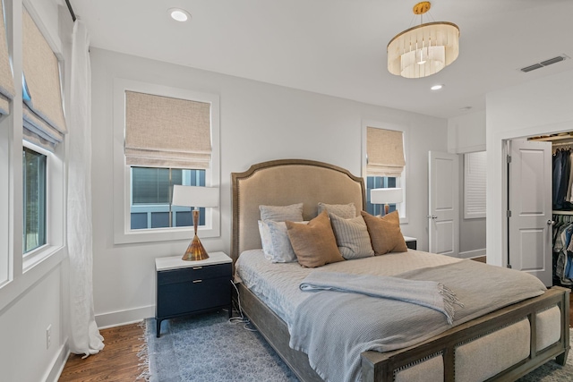 bedroom with dark hardwood / wood-style flooring and an inviting chandelier