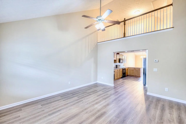 unfurnished living room featuring high vaulted ceiling, ceiling fan, and light hardwood / wood-style floors