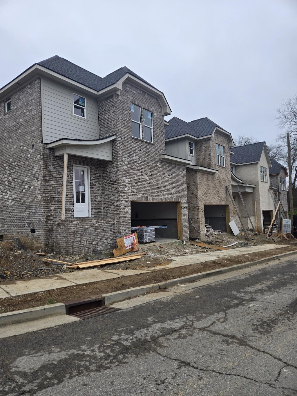 view of side of property with an attached garage, central air condition unit, and brick siding