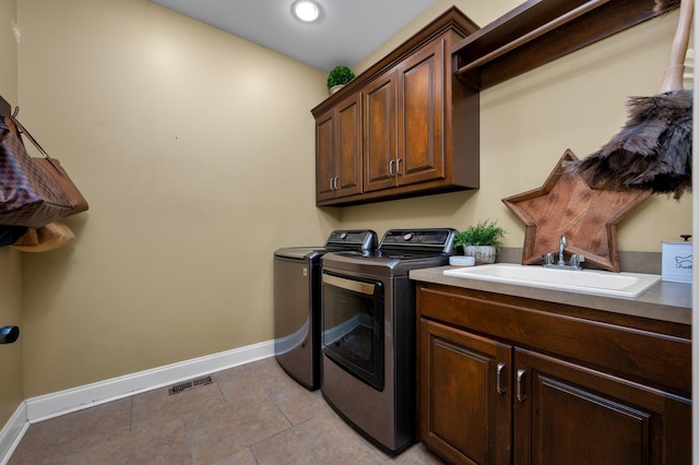 laundry area featuring cabinets, independent washer and dryer, and sink