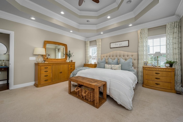 bedroom with light colored carpet, multiple windows, and a tray ceiling