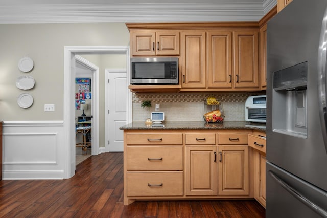 kitchen with dark stone counters, crown molding, tasteful backsplash, dark hardwood / wood-style flooring, and stainless steel appliances