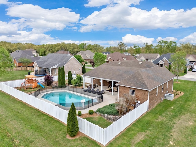 view of swimming pool featuring a lawn, a patio area, and a playground