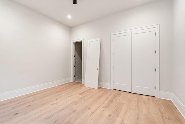 unfurnished bedroom with light hardwood / wood-style floors and a closet