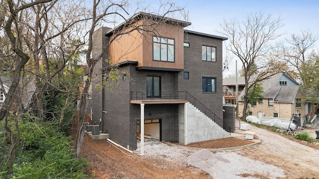 rear view of property with central AC