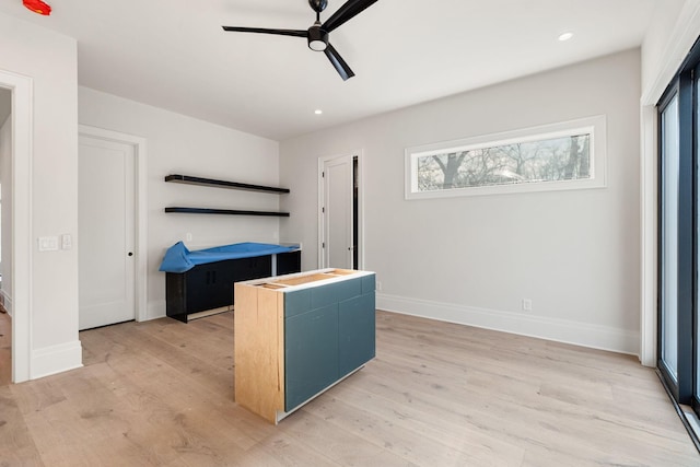 kitchen with blue cabinetry, light wood-type flooring, and ceiling fan