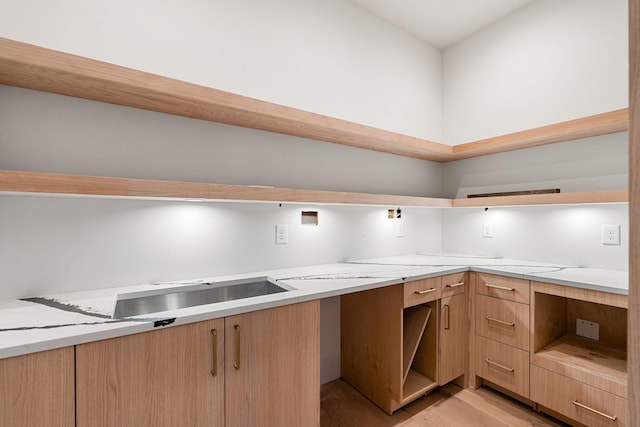 kitchen with light stone countertops and light hardwood / wood-style flooring