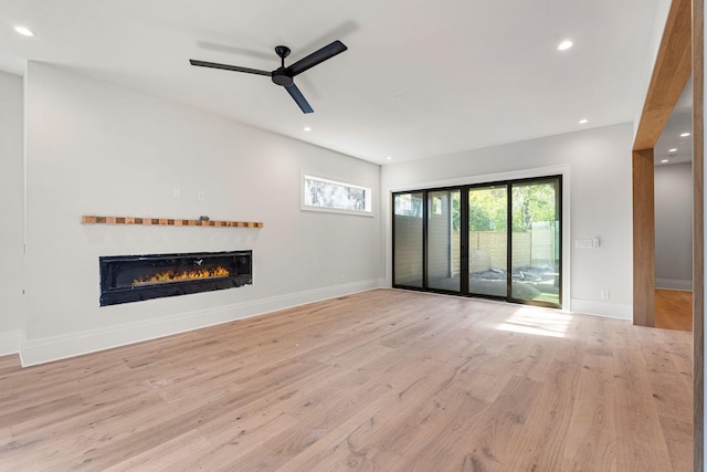 unfurnished living room featuring ceiling fan and light wood-type flooring