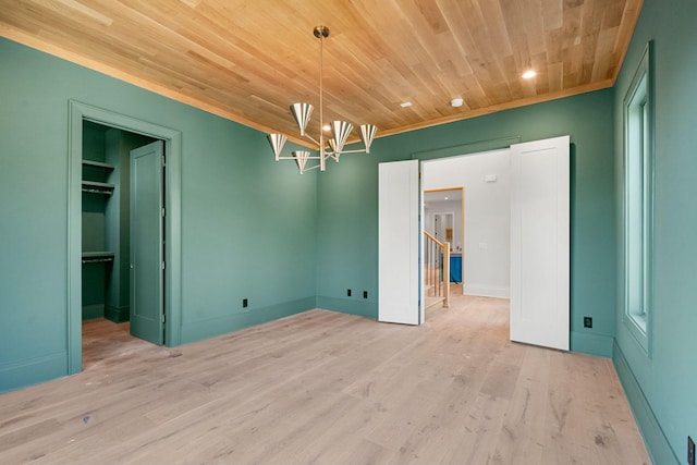 spare room with light hardwood / wood-style floors, a notable chandelier, and wood ceiling