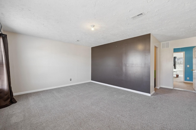 spare room with a textured ceiling and carpet