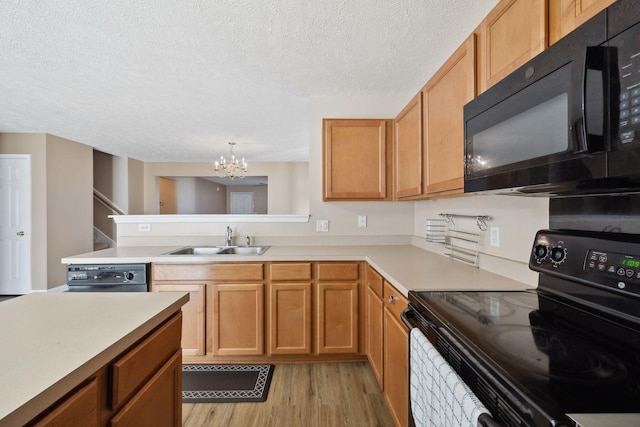 kitchen featuring sink, black appliances, light hardwood / wood-style floors, a textured ceiling, and a chandelier