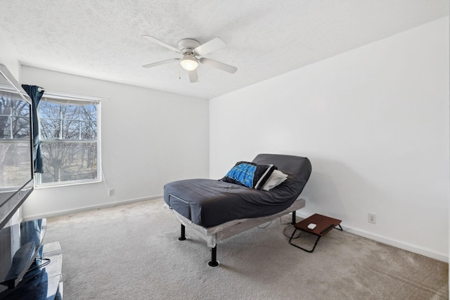 sitting room with light carpet, ceiling fan, and a textured ceiling