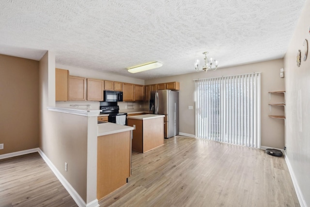 kitchen featuring a notable chandelier, light hardwood / wood-style floors, and black appliances