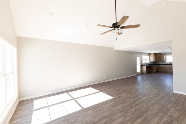 unfurnished living room featuring dark hardwood / wood-style flooring, high vaulted ceiling, ceiling fan, and sink