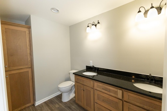 bathroom with hardwood / wood-style floors, vanity, and toilet