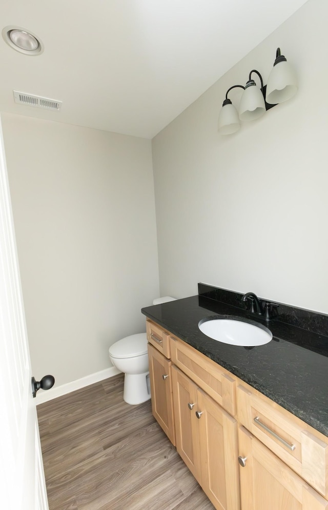 bathroom featuring vanity, hardwood / wood-style flooring, and toilet