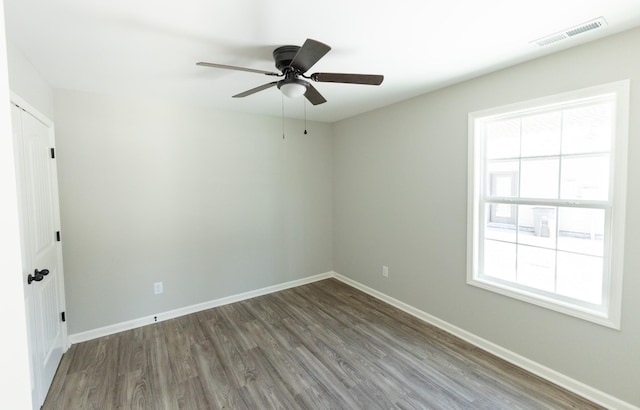 spare room featuring hardwood / wood-style floors, a wealth of natural light, and ceiling fan