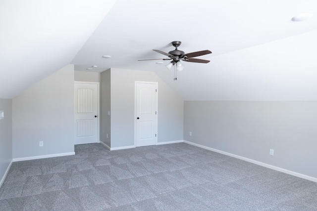 bonus room featuring ceiling fan, dark carpet, and lofted ceiling