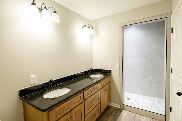 bathroom with hardwood / wood-style floors, vanity, and a shower