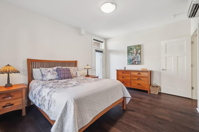 bedroom with an AC wall unit and dark wood-type flooring