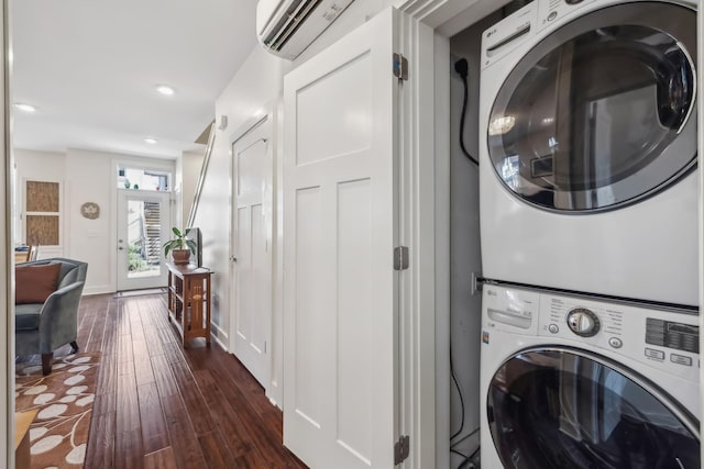 laundry area featuring dark hardwood / wood-style floors, stacked washing maching and dryer, and a wall mounted AC