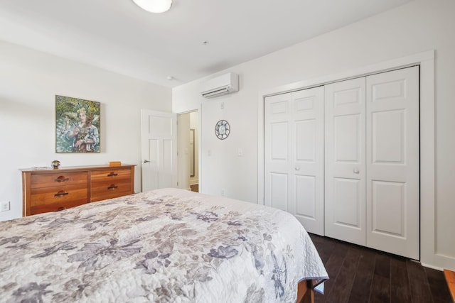 bedroom featuring dark hardwood / wood-style flooring, an AC wall unit, and a closet